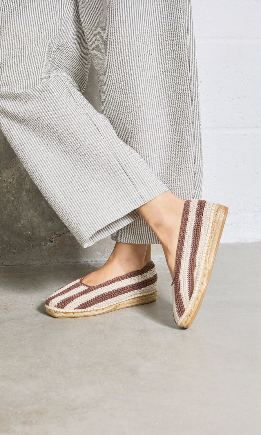 Plümo- Person wearing wide-leg striped pants and Basque Espadrilles with cushioned insoles, standing on concrete.